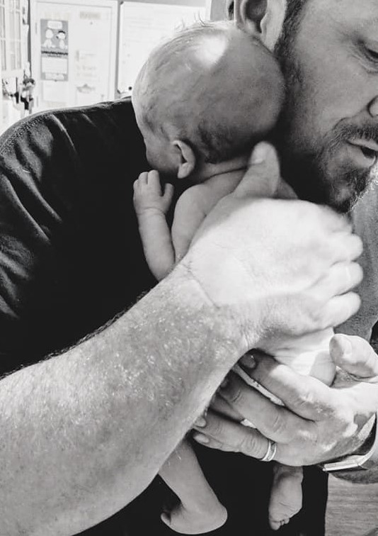 man comforting preemie baby