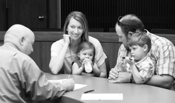 family at court signing adoption papers