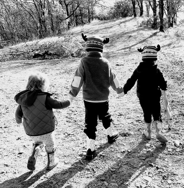 3 kids holding hands and walking